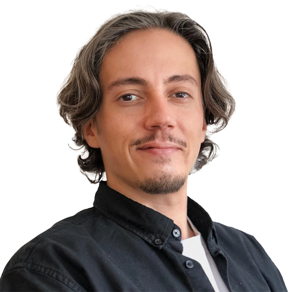 Headshot of a person with medium-length wavy hair and a dark shirt, smiling slightly